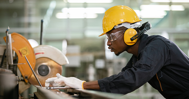 A worker wearing safety headphones while working in a loud environment