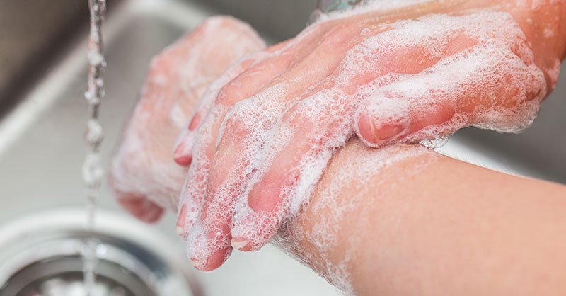 Close-up of person hands, washing with soap in sink