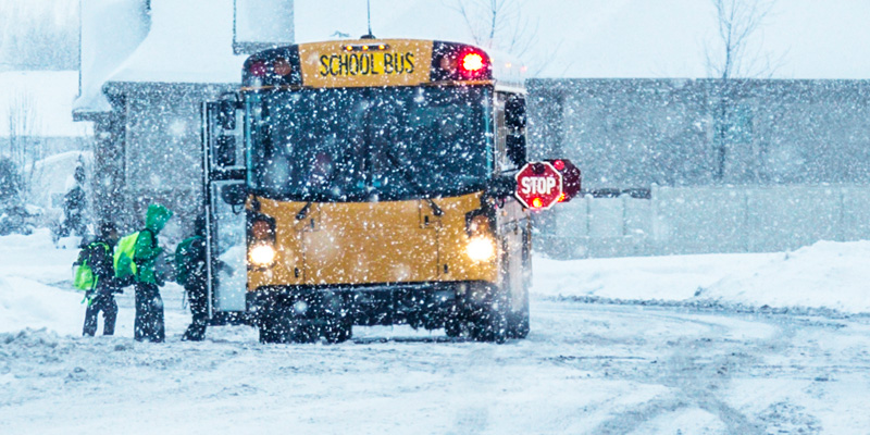 School bus picking up grade school students during a heavy snow fall