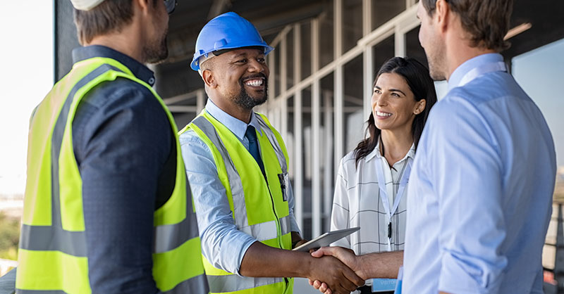 Construction workers meeting with visitor on a construction site