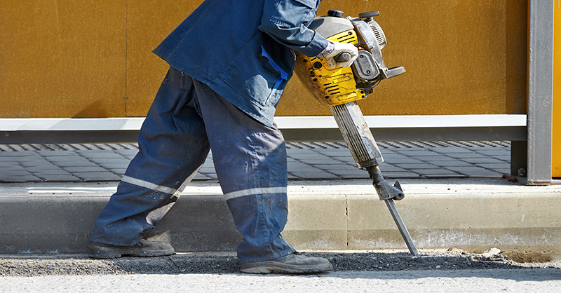 Construction worker using jack hammer